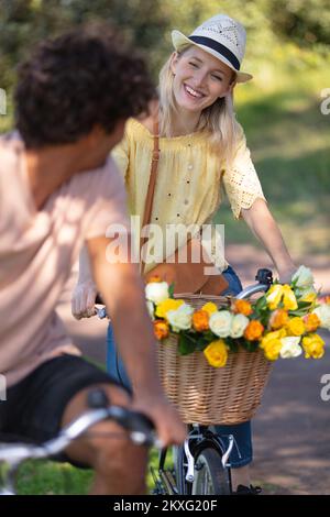 felice coppia che si inseguono a vicenda in bicicletta Foto Stock