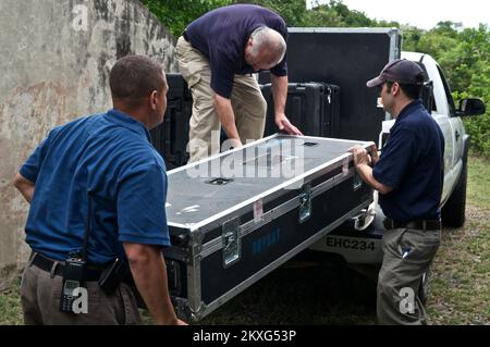 Grave tempesta - Saint Thomas, US Virgin Islands, 3 agosto 2011 membri della Regione FEMA 2 IMAT spostare le apparecchiature di comunicazione VSAT (Very Small aperture Terminal) dal deposito a 'The Bunker' sulla ST. Thomas. Il sistema VSAT fornisce comunicazioni di backup per l'IMAT in caso di perdita delle comunicazioni principali. Nella foto sono raffigurati il capo della sezione logistica John Alonso, lo specialista delle comunicazioni Sean Kielty e il capo dell'unità di supporto a terra Gary Cimorelli. Fotografie relative a disastri e programmi, attività e funzionari di gestione delle emergenze Foto Stock