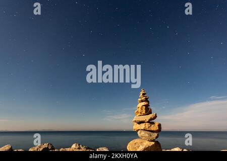 Vista del cielo notturno e sculture di pietre impilate, sull'isola di Vir, Croazia, il 2 agosto 2020. L'isola di Vir è una delle 300 isole e isolette dell'arcipelago di Zara, una delle 1186 isole e isolette nell'Adriatico croato. Passato nel mare di Vir nella parte settentrionale della Dalmazia. Foto: Davor Puklavec/PIXSELL Foto Stock