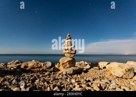 Vista del cielo notturno e sculture di pietre impilate, sull'isola di Vir, Croazia, il 2 agosto 2020. L'isola di Vir è una delle 300 isole e isolette dell'arcipelago di Zara, una delle 1186 isole e isolette nell'Adriatico croato. Passato nel mare di Vir nella parte settentrionale della Dalmazia. Foto: Davor Puklavec/PIXSELL Foto Stock
