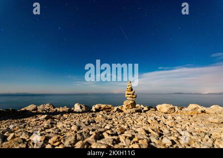 Vista del cielo notturno e sculture di pietre impilate, sull'isola di Vir, Croazia, il 2 agosto 2020. L'isola di Vir è una delle 300 isole e isolette dell'arcipelago di Zara, una delle 1186 isole e isolette nell'Adriatico croato. Passato nel mare di Vir nella parte settentrionale della Dalmazia. Foto: Davor Puklavec/PIXSELL Foto Stock