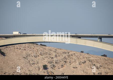 Vista del ponte di Krk, in Croazia, ago. 10, 2020. Il ponte di Krk, lungo 1,43 km, collega la più meridionale e la più grande isola croata con la terraferma. Si compone di due archi, l'arco grande e l'arco piccolo. La Gola del canale di Tihi è collegata al Grande Arco e il canale di Burni al piccolo Arco. L'arco grande è di 390 m, ed è il più lungo arco a struttura in cemento armato del mondo. La sezione è situata sulla strada statale D102. Foto: Nel Pavletic/PIXSELL Foto Stock