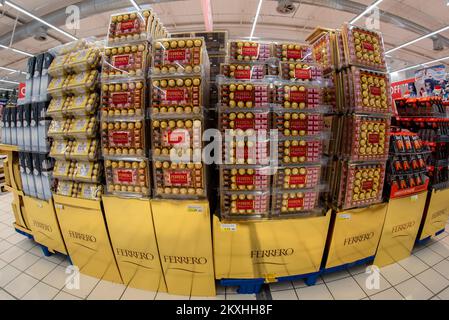 Bra, Cuneo, Italia - 30 novembre 2022: Pallet d'oro con confezioni regalo Ferrero Prestige con cioccolatini Mon Cheri, Rocher e Pocket Coffee per s Foto Stock