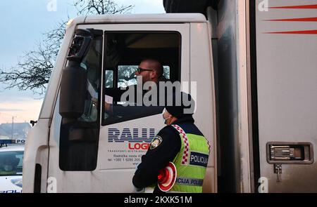 La polizia sui posti di controllo tra la contea di Brod-Posavina e la contea di Pozega-Slavonia controlla il pass di viaggio, a Blice, in Croazia, il 23 dicembre 2020. Da oggi è vietato lasciare la contea in cui la persona ha una residenza permanente o temporanea. Ciò non si applica al personale necessario per la manutenzione del traffico, alla migrazione quotidiana dei dipendenti nei servizi sanitari, alla consegna di farmacia, alle utenze, alla fornitura di gas ed elettricità, ai servizi di sicurezza, ai giornalisti, ai pazienti, ai viaggi da e per il lavoro, ai servizi di emergenza per prevenire la diffusione delle malattie e al personale diplomatico. Il divieto di viaggio entra in per Foto Stock