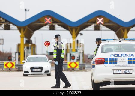 La polizia sui posti di controllo all'entrata dell'autostrada nella contea di Zara controlla il pass di viaggio, a Zara, Croazia, il 23 dicembre 2020. Da oggi è vietato lasciare la contea in cui la persona ha una residenza permanente o temporanea. Ciò non si applica al personale necessario per la manutenzione del traffico, alla migrazione quotidiana dei dipendenti nei servizi sanitari, alla consegna di farmacia, alle utenze, alla fornitura di gas ed elettricità, ai servizi di sicurezza, ai giornalisti, ai pazienti, ai viaggi da e per il lavoro, ai servizi di emergenza per prevenire la diffusione delle malattie e al personale diplomatico. Il divieto di viaggio entra in vigore il dicembre Foto Stock