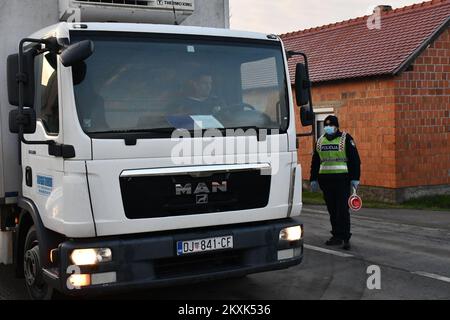 La polizia sui posti di controllo tra la contea di Brod-Posavina e la contea di Pozega-Slavonia controlla il pass di viaggio, a Blice, in Croazia, il 23 dicembre 2020. Da oggi è vietato lasciare la contea in cui la persona ha una residenza permanente o temporanea. Ciò non si applica al personale necessario per la manutenzione del traffico, alla migrazione quotidiana dei dipendenti nei servizi sanitari, alla consegna di farmacia, alle utenze, alla fornitura di gas ed elettricità, ai servizi di sicurezza, ai giornalisti, ai pazienti, ai viaggi da e per il lavoro, ai servizi di emergenza per prevenire la diffusione delle malattie e al personale diplomatico. Il divieto di viaggio entra in per Foto Stock