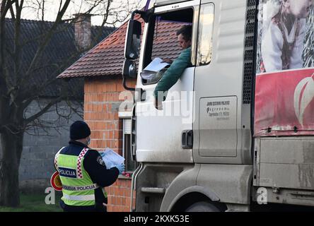 La polizia sui posti di controllo tra la contea di Brod-Posavina e la contea di Pozega-Slavonia controlla il pass di viaggio, a Blice, in Croazia, il 23 dicembre 2020. Da oggi è vietato lasciare la contea in cui la persona ha una residenza permanente o temporanea. Ciò non si applica al personale necessario per la manutenzione del traffico, alla migrazione quotidiana dei dipendenti nei servizi sanitari, alla consegna di farmacia, alle utenze, alla fornitura di gas ed elettricità, ai servizi di sicurezza, ai giornalisti, ai pazienti, ai viaggi da e per il lavoro, ai servizi di emergenza per prevenire la diffusione delle malattie e al personale diplomatico. Il divieto di viaggio entra in per Foto Stock