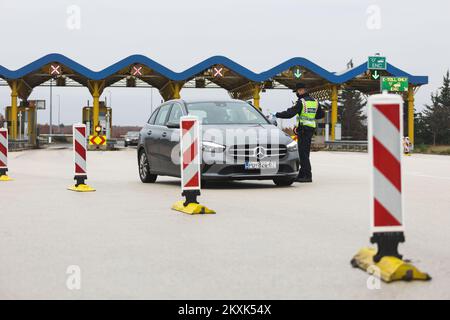 La polizia sui posti di controllo all'entrata dell'autostrada nella contea di Zara controlla il pass di viaggio, a Zara, Croazia, il 23 dicembre 2020. Da oggi è vietato lasciare la contea in cui la persona ha una residenza permanente o temporanea. Ciò non si applica al personale necessario per la manutenzione del traffico, alla migrazione quotidiana dei dipendenti nei servizi sanitari, alla consegna di farmacia, alle utenze, alla fornitura di gas ed elettricità, ai servizi di sicurezza, ai giornalisti, ai pazienti, ai viaggi da e per il lavoro, ai servizi di emergenza per prevenire la diffusione delle malattie e al personale diplomatico. Il divieto di viaggio entra in vigore il dicembre Foto Stock