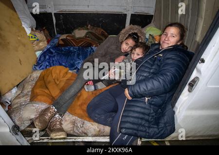 Djurdja Hudorovic con i suoi nipoti nel furgone dove trascorreranno la notte. Diverse famiglie trascorrono la notte in auto e furgoni sul campo da pallacanestro. Molte persone hanno perso le loro case, e molti non possono entrarle a causa di danni. Un forte terremoto ha colpito la Croazia ieri, l'epicentro del terremoto di magnitudo 6,2 è stato a 3 chilometri da Petrinja, a Glina, Croazia, il 30 dicembre 2020. Foto: Davor Puklavec/PIXSELL Foto Stock