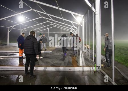 I lavoratori sollevano una tenda per le persone le cui case sono state distrutte nel terremoto. Diverse famiglie trascorrono la notte in auto e furgoni sul campo da pallacanestro. Molte persone hanno perso le loro case, e molti non possono entrarle a causa di danni. Un forte terremoto ha colpito la Croazia ieri, l'epicentro del terremoto di magnitudo 6,2 è stato a 3 chilometri da Petrinja, a Glina, Croazia, il 30 dicembre 2020. Foto: Davor Puklavec/PIXSELL Foto Stock