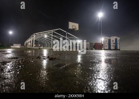 I lavoratori sollevano una tenda per le persone le cui case sono state distrutte nel terremoto. Diverse famiglie trascorrono la notte in auto e furgoni sul campo da pallacanestro. Molte persone hanno perso le loro case, e molti non possono entrarle a causa di danni. Un forte terremoto ha colpito la Croazia ieri, l'epicentro del terremoto di magnitudo 6,2 è stato a 3 chilometri da Petrinja, a Glina, Croazia, il 30 dicembre 2020. Foto: Davor Puklavec/PIXSELL Foto Stock