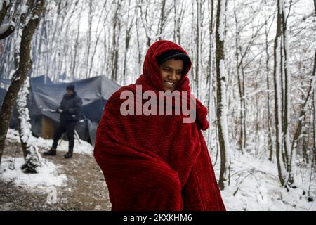 I migranti si riscaldano nel campo di fortuna nel bosco, vicino a Velika Kladusa, Bosnia-Erzegovina, il 14 gennaio 2021. Diverse centinaia di migranti, per la maggior parte provenienti dal Bangladesh, hanno fatto campi nei boschi vicino a Velika Kladusa e attende la primavera per cercare di attraversare le frontiere per i paesi dell'Unione europea. L'Organizzazione internazionale per le migrazioni (OIM) fornisce loro cibo, abbigliamento e calzature. Attualmente in Bosnia vi sono circa 8.000 migranti e rifugiati provenienti dal Medio Oriente, dall'Asia e dall'Africa. Foto: Armin Durgut/PIXSELL Foto Stock