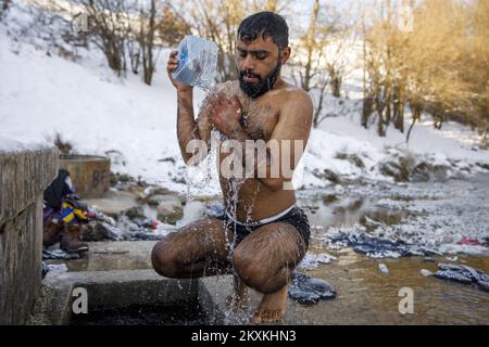 Un migrante dal Pakistan Hagiaz Abdulrehman si pulisce in un flusso nel campo migrante Lipa, vicino Bihac, Bosnia-Erzegovina, il 15 gennaio 2021. L'acqua nei serbatoi si è congelata questa mattina perché la temperatura alle ore 9 era di -14 gradi Celsius. Il Camp Lipa sarà completamente funzionale in 3 mesi. Foto: Armin Durgut/PIXSELL Foto Stock