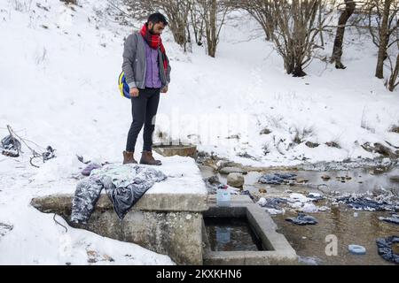 Un migrante dal Pakistan Hagiaz Abdulrehman si pulisce in un flusso nel campo migrante Lipa, vicino Bihac, Bosnia-Erzegovina, il 15 gennaio 2021. L'acqua nei serbatoi si è congelata questa mattina perché la temperatura alle ore 9 era di -14 gradi Celsius. Il Camp Lipa sarà completamente funzionale in 3 mesi. Foto: Armin Durgut/PIXSELL Foto Stock