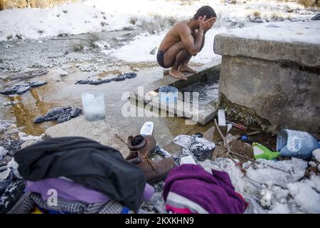 Un migrante dal Pakistan Hagiaz Abdulrehman si pulisce in un flusso nel campo migrante Lipa, vicino Bihac, Bosnia-Erzegovina, il 15 gennaio 2021. L'acqua nei serbatoi si è congelata questa mattina perché la temperatura alle ore 9 era di -14 gradi Celsius. Il Camp Lipa sarà completamente funzionale in 3 mesi. Foto: Armin Durgut/PIXSELL Foto Stock