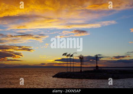 Alba nel porto di Termoli, si può vedere la silhouette di fari e bandiere che soffiano nel vento - Molise, Mare Adriatico Foto Stock