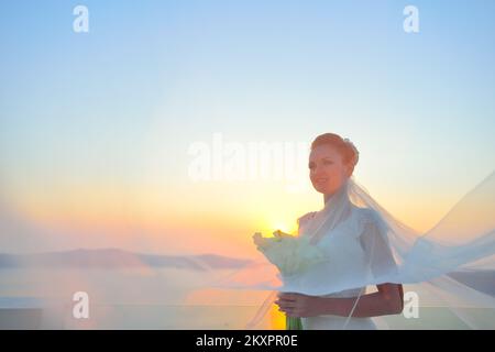 Bella donna in posa in bianco abito da sposa su Santorini Island, Grecia Foto Stock