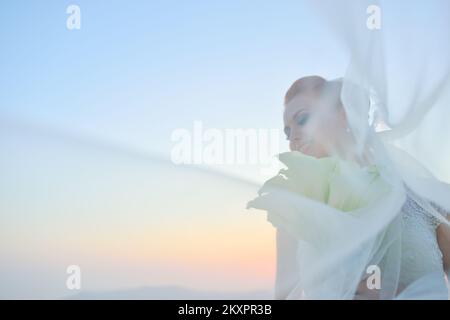 Bella donna in posa in bianco abito da sposa su Santorini Island, Grecia Foto Stock