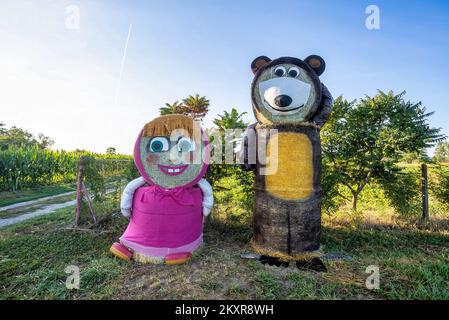 Personaggi dei cartoni animati Masha e l'orso fatto di balle di fieno visto all'ingresso di Jelisavac vicino Nasice, in Croazia, il 13 agosto 2021, Foto:Davor Javorovic/PIXSELL Foto Stock