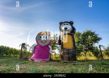 Personaggi dei cartoni animati Masha e l'orso fatto di balle di fieno visto all'ingresso di Jelisavac vicino Nasice, in Croazia, il 13 agosto 2021, Foto:Davor Javorovic/PIXSELL Foto Stock