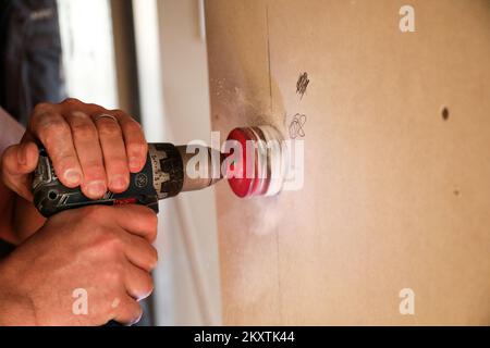 Lavoratore con speciale trapano utensile elettrico per presa elettrica durante la ristrutturazione di Homer Zagreb, Croazia, il 18 settembre 2021. Foto: Emica Elvedji/PIXSELL Foto Stock