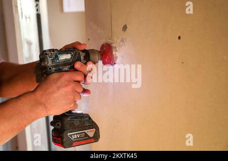 Lavoratore con speciale trapano utensile elettrico per presa elettrica durante la ristrutturazione di Homer Zagreb, Croazia, il 18 settembre 2021. Foto: Emica Elvedji/PIXSELL Foto Stock