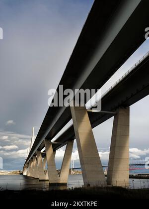 Queensferry attraversare il ponte Firth of Forth visto direttamente da sotto il ponte nel Queensferry Sud; Forth ponte ferroviario in background. Foto Stock