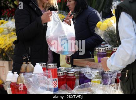 Una donna acquista fiori e candele da mettere sulla tomba del parente Priore di tutti i Santi giorno a Sibenik, Croazia, il 31 ottobre 2021. Foto: Dusko Jaramaz/PIXSELL Foto Stock