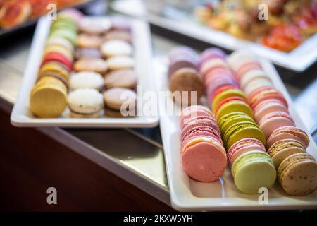 Coloratissimi macaroon francesi su un piatto bianco lucido pronti per una festa di compleanno. Foto di alta qualità Foto Stock