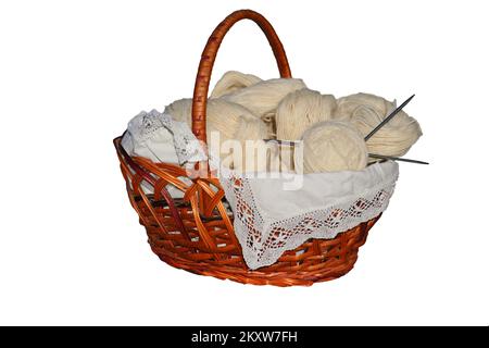 Il cestello contiene fili per maglieria, aghi per maglieria e una sfera di filo. Foto Stock