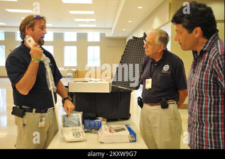 Uragano alluvione/tempesta tropicale - Gulfport, Miss. , 8 settembre 2012 Disabilities Integration Specialist Mike Houston mostra al personale del Centro di recupero di emergenza come utilizzare le attrezzature per aiutare le persone con disabilità a registrarsi per l'assistenza. . Uragano Mississippi Isaac. Fotografie relative a disastri e programmi, attività e funzionari di gestione delle emergenze Foto Stock
