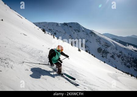 Marmaros, i Carpazi, UCRAINA - 15 2021 marzo: Sciatore femminile in discesa durante la giornata di sole in alta montagna Foto Stock