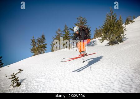 Marmaros, i Carpazi, UCRAINA - 15 2021 marzo: Sciatori sci e salto in discesa durante la giornata di sole in alta montagna Foto Stock