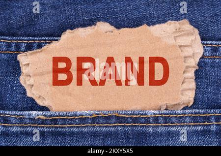 Affari e finanza. Una scatola di cartone con la marca di iscrizione si stacca dai jeans. Foto Stock