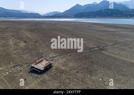 Il lago Jablanicko può essere visto nella foto a Liscici, Bosnia-Erzegovina il 21 marzo 2022. Dopo che il lago Jablanicko quasi completamente asciugato alcune settimane fa, oggi la situazione è un po 'meglio, l'acqua è versato nel letto del fiume. All'inizio del secondo mese, l'acqua del lago di Jablanica si è ritirata, lasciando dietro scene inquietanti di depressioni del lago esposte. Foto: Armin Durgut/PIXSELL Foto Stock