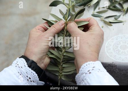 La lavorazione a maglia dei rami di ulivo può essere vista nella foto a Bodarica, Croazia, il 9 aprile 2022. La lavorazione a maglia dei rami d'ulivo è un'abitudine tradizionale per la più grande vacanza cristiana, la Pasqua. Foto: Dusko Jaramaz/PIXSELL Foto Stock