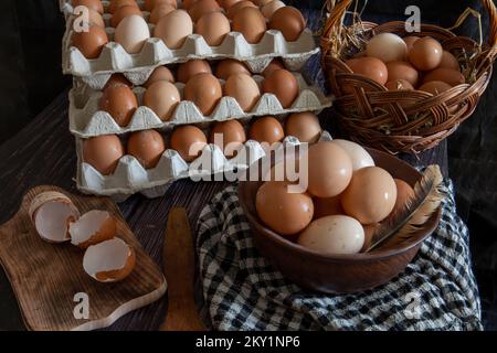 Uova di pollo in un piatto di argilla e vassoi sul tavolo. Foto Stock
