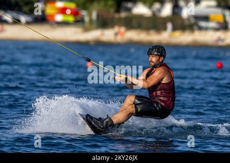 Gli appassionati di adrenalina partecipano al wakeboarding al Wake Park Pula di Pola, Croazia, il 6 luglio 2022. I turisti cercavano rifugio dal caldo insopportabile di Pola sotto gli ombrelloni, o per coloro che amano ancora l'attività e l'adrenalina, hanno provato il wakeboarding a Wake Park Pula. Foto: Srecko Niketic/PIXSELL Foto Stock