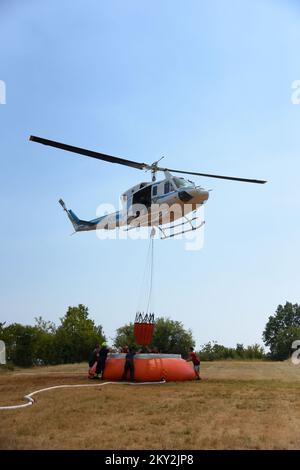 I vigili del fuoco utilizzano un elicottero per cercare di estinguere un incendio nel villaggio di Temnica, in Slovenia, il 22 luglio 2022. Circa 1.000 vigili del fuoco combattono un grande incendio forestale nella Slovenia occidentale. L'incendio, soffiato dal vento proveniente dall'Italia orientale, ha portato all'evacuazione di diversi villaggi. Foto: SASA Miljevic/PIXSELL Foto Stock