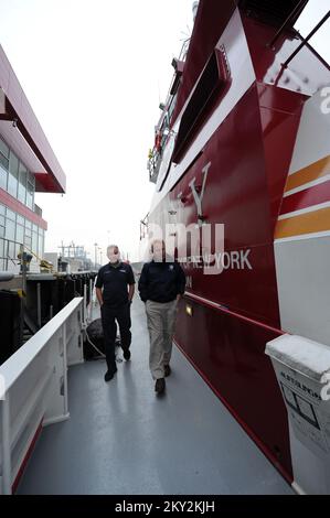 New York, N.Y., 1 dicembre 2012, ufficiale di coordinamento federale Michael Byrne, a destra, ottiene un giro di Fireboat II, attraccato alla stazione di Marine 9 dal pompiere Brian Masterson. Il motoscafo antincendio, che serve tutto il porto di New York, è attraccato presso la FDNY Marine 9 Barracks presso l'ex sito portuale Navy Home a Stapleton, Staten Island. Il piroscafo ricevette qualche danno dall'impennata della tempesta a seguito dell'uragano Sandy. New York, NY, 1 dicembre 2012--ufficiale federale di coordinamento Michael Byrne, a destra, ottiene un giro di Marine 9 fuoco barca dal pompiere Brian Masterson. La barca dei vigili del fuoco, che serve tutto il New Yor Foto Stock