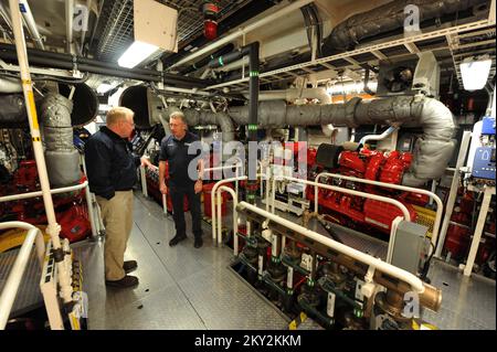 New York, N.Y., 1 dicembre 2012 l'ufficiale di coordinamento federale Michael Byrne, partito, ottiene un giro delle pompe in Fire Boat II, attraccato alla stazione di Marine 9 dal pompiere Brian Masterson. Il motoscafo antincendio, che serve tutto il porto di New York, è attraccato presso la FDNY Marine 9 Barracks presso l'ex sito Navy Homeport a Stapleton, Staten Island. Il piroscafo ricevette qualche danno dall'impennata della tempesta a seguito dell'uragano Sandy. New York, NY, 1 dicembre 2012--ufficiale di coordinamento federale Michael Byrne, a sinistra, ottiene un giro delle pompe in barca di fuoco marina 9 dal caccia al fuoco Brian Masterson. La barca dei vigili del fuoco, Whi Foto Stock