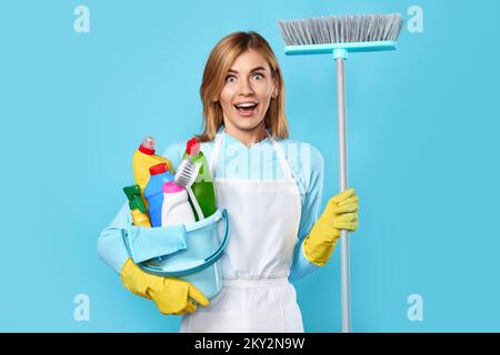 donna in guanti che regge secchio di detergenti e scopa Foto Stock