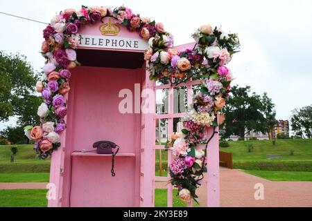 Una cabina telefonica rosa decorata con fiori adorna il prato del Castello Pejacevic recentemente ristrutturato a Virovitica, Croazia, il 2 settembre 2022. Foto: Damir Spehar/PIXSELL Foto Stock