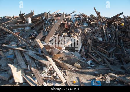 Queens, N.Y., 18 gennaio 2013 i detriti dell'uragano Sandy vengono processati presso il Jacob Riis Park, a far Rockaway, N.Y. dove gli Stati Uniti Il corpo degli ingegneri dell'esercito sta lavorando per pulirlo e smistarlo in pile per riciclarlo. Mucchi di detriti contenenti pali telefonici, tiranti ferroviari, alberi, 2x4 e altri oggetti aspettano di essere smistati. La FEMA fornisce finanziamenti per la rimozione dei detriti attraverso il programma di assistenza pubblica. K.C.WILSEY/FEMA. L'uragano Sandy di New York. Fotografie relative a disastri e programmi, attività e funzionari di gestione delle emergenze Foto Stock