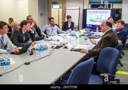 Queens, N.Y., 25 aprile 2013 la FEMA ha ospitato funzionari municipali e di gestione delle emergenze di Stoccolma, Svezia presso il JFO (New York Joint Field Office) per informarli sulle operazioni di ripristino di emergenza per l'uragano Sandy. Robert Tranter, capo filiale di assistenza per la riduzione dei rischi, discute i modi per ridurre o eliminare i rischi a lungo termine per le persone e le proprietà. K.C.WILSEY/FEMA. L'uragano Sandy di New York. Fotografie relative a disastri e programmi, attività e funzionari di gestione delle emergenze Foto Stock