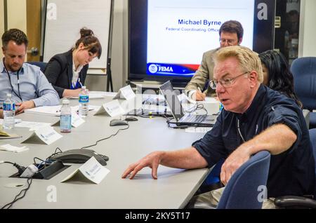 Queens, N.Y., 25 aprile 2013 la FEMA ha ospitato funzionari municipali e di gestione delle emergenze di Stoccolma, Svezia presso il JFO (New York Joint Field Office) per informarli sulle operazioni di ripristino di emergenza per l'uragano Sandy. Michael Byrne, funzionario federale di coordinamento, fornisce informazioni ai visitatori sulle operazioni di risposta e recupero della FEMA. K.C.WILSEY/FEMA. L'uragano Sandy di New York. Fotografie relative a disastri e programmi, attività e funzionari di gestione delle emergenze Foto Stock
