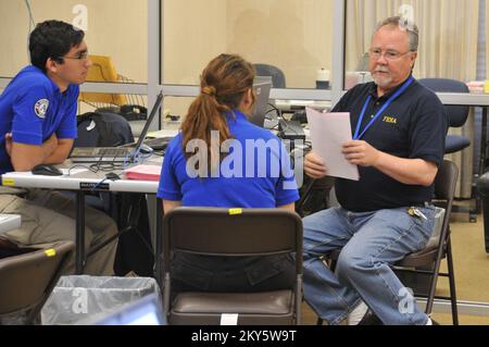 West, Texas, 4 maggio 2013 Michael Hamm (a destra), un operatore dei servizi di disastro dell'agenzia federale di gestione di emergenza, spiega il funzionamento del centro Unito di disaster recovery statale-federale ai membri del corpo di FEMA Ryan Hutson (a sinistra), di Queens, N. Y., e Allisan Gray (centro), di Blue Hill, Maine. Il centro assiste i residenti della zona colpiti dalla recente esplosione dell'impianto di fertlizer. Norman Lenburg/FEMA.. Fotografie relative a disastri e programmi, attività e funzionari di gestione delle emergenze Foto Stock