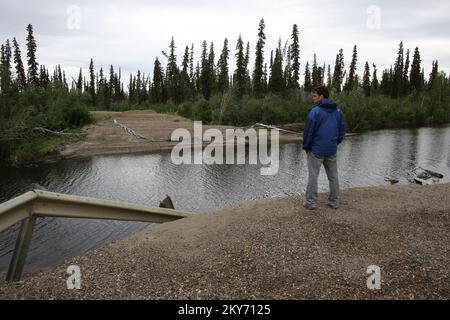 Galena, Alaska, 30 giugno 2013 Jeremy Zidek, ufficiale dello Stato dell'Alaska, osserva il sito dell'ex ponte che è stato distrutto a causa delle gravi inondazioni che si sono abbattute dal maggio 17 al giugno 11th. Il finanziamento federale sotto forma di assistenza pubblica è disponibile per le amministrazioni locali statali, tribali e ammissibili su una base di ripartizione dei costi per i lavori di emergenza e la riparazione e la sostituzione di strutture danneggiate dall'inondazione nell'area regionale di frequenza educativa dell'Alaska Gateway (REAA). Adam DuBrowa/ FEMA.. Fotografie relative a disastri e programmi, attività e funzionari di gestione delle emergenze Foto Stock