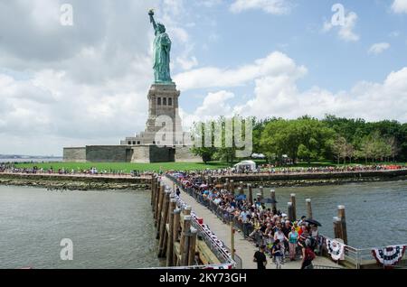 Liberty Island, N.Y., 4 luglio 2013 i visitatori provenienti da tutto il mondo sono tornati a Liberty Island per la riapertura ufficiale della Statua della libertà. L'uragano Sandy ha allagato il 75%%%%%%%%%%%%%% Dell'isola nell'ottobre 2012 causando gravi danni alle sue infrastrutture e strutture. La Statua fu riaperta il 4th luglio dopo otto mesi di riparazioni. I visitatori hanno aspettato in fila per salire a bordo del traghetto per il viaggio di ritorno a Manhattan. K.C.WILSEY/FEMA. L'uragano Sandy di New York. Fotografie relative a disastri e programmi, attività e funzionari di gestione delle emergenze Foto Stock