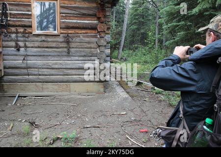 Hughes, Alaska, 8 luglio 2013 l'ispettore della FEMA Marty Williams esamina questa sede che è stata galleggiato fuori della relativa fondazione da inondazione severa. Gli individui e gli imprenditori che hanno subito perdite nell'area designata possono iniziare a richiedere assistenza registrandosi all'indirizzo www.disasterassistance.gov o chiamando il numero 1-800-621-FEMA (3362). Adam Dubrowa/ FEMA.. Fotografie relative a disastri e programmi, attività e funzionari di gestione delle emergenze Foto Stock